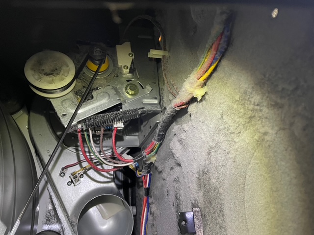 Inside dryer cabinet before cleaning — heavy lint buildup